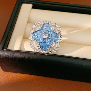 Close-up of vintage blue enamel flower ring with sparkling rhinestone accents.