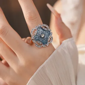 Elegant blue enamel flower ring with crystal border on finger for vintage style