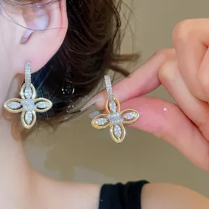 Close-up showing the intricate zircon pavé detail of 18k gold-plated flower earrings