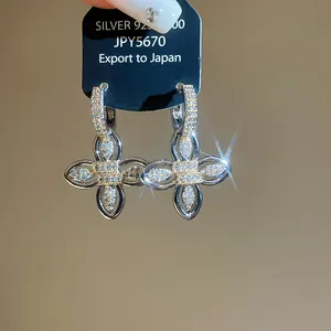 Macro detail of luxury sparkling zircon flower hoop earrings in 18k gold plating