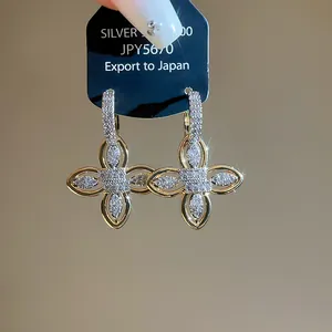 Detailed macro view of 18k gold plated flower earrings set with sparkling pavé zircon
