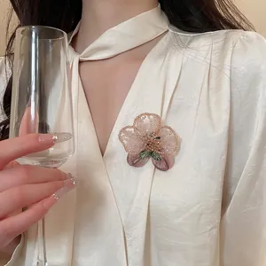 Elegant vintage handmade crystal beaded flower brooch displayed on a beige silk blouse