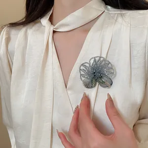 Elegant vintage crystal beaded flower brooch with hand-embroidered details on cream blouse