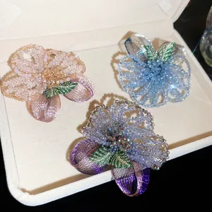 Detail of vintage crystal beaded flower brooches with wire embroidery in a jewelry box