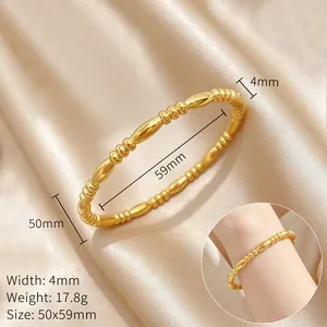 Detail view of a gold beaded steel bangle on silk with 50x59mm dimension labels