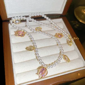 Vue détaillée d'un collier de perles style français avec pendentifs tulipes en cristal.