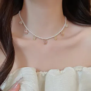 Élégant collier vintage français avec petites perles et pendentifs tulipes sur le cou
