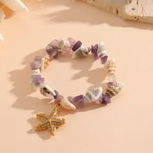 Primo piano di bracciale estivo con conchiglie, pietre viola e ciondolo a stella marina