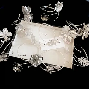 Elegant silver metal arm cuffs with intricate flower and leaf designs for stylish women