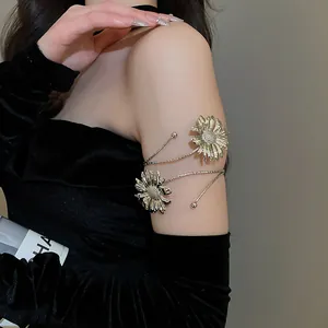 Close-up detail of an elegant silver metal daisy floral arm cuff on a model's upper arm.