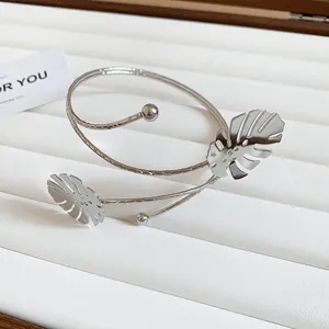 Detailed view of a silver Monstera leaf upper arm cuff on a white jewelry display tray