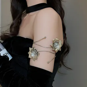 Elegant golden metal flower arm cuff jewelry piece shown in detail on a model's upper arm