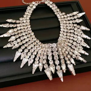 Statement fringe necklace with round and teardrop rhinestones on a black jewelry tray