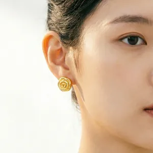 Élégantes boucles d'oreilles rose 3D en finition or vintage portées par un modèle
