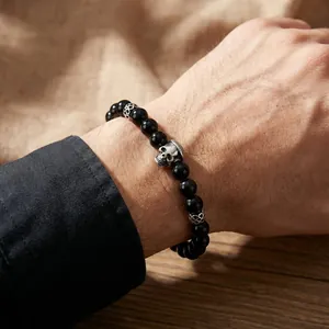 Detail of men's beaded bracelet with black onyx beads and vintage silver skull charm