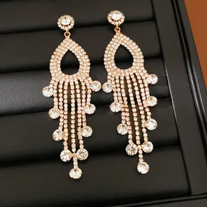 Dettaglio orecchini a nappina eleganti con strass brillanti e raffinato design traforato.