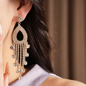 Primo piano di orecchini con nappe in strass e design a goccia traforato in argento