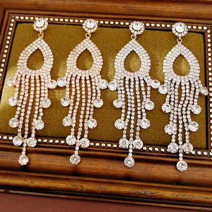 Primo piano di orecchini a nappa con strass scintillanti in oro rosa e argento