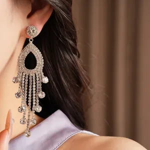 Dettaglio di eleganti orecchini pendenti con strass scintillanti e lunghe nappe.