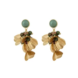 Boucles d'oreilles pétales dorées vintage avec pierres vertes naturelles sur blanc