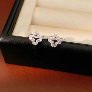 Detailed macro view of silver hollow clover hoop earrings with shimmering zircon pavé