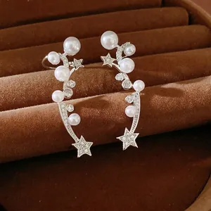 Elegant zircon star and pearl ear clips for unpierced ears on brown velvet