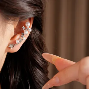 Detail shot of elegant zircon star and pearl ear cuff showing the wearing effect