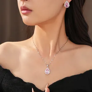 Detailed view of pink pear-shaped zircon necklace and earrings set worn by a model