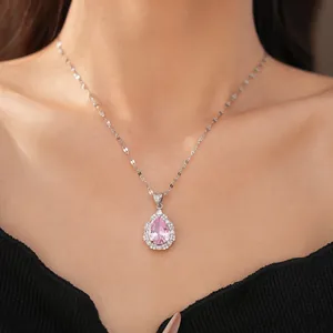 Detail view of a luxury pink teardrop zircon necklace worn by a model in black dress