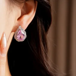 Macro detail view of elegant pink teardrop zircon earring featuring a crystal halo