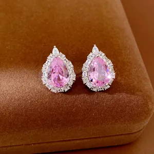 Detailed close-up view of elegant pink pear-shaped cubic zirconia stud earrings on velvet.
