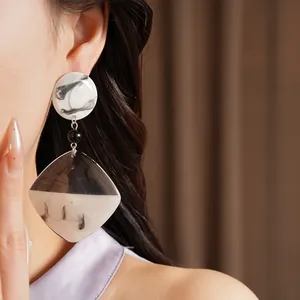 Detail view of stylish resin square drop earrings with ink-wash pattern and silver needles