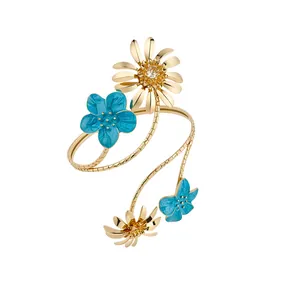 Eleganter goldener Spiralarmreif mit blauen und goldenen Emaille-Blumenanhängern für Damen