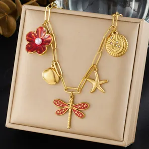 Detail view of gold-plated dragonfly necklace with multi-element floral charms