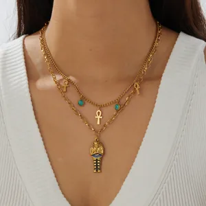 Dettaglio di collana a strati in acciaio dorato con ciondoli Ankh e faraone egiziano
