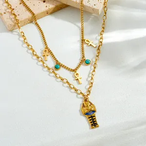 Dettaglio della collana a strati in acciaio dorato con croce Ankh e pendente di faraone