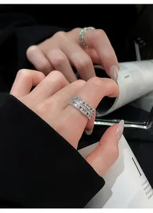 Macro detailed view of women's silver-tone lace-edge open ring set with cubic zircons