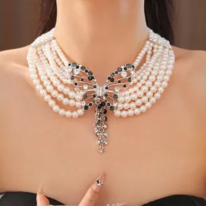 Elegante collana di perle a più fili con un grande ciondolo a farfalla in strass.