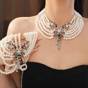 Primo piano di collana di perle multistrato con ciondolo a farfalla traforato