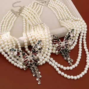 Primo piano di una collana di perle a più strati con ciondolo a farfalla di strass