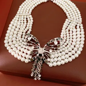 Vista dettagliata di un'elegante collana di perle bianche multifilo con grande farfalla di cristallo