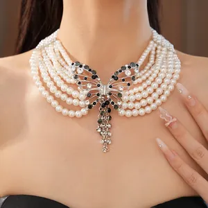 Dettaglio della collana di perle multi-filo con pendente a farfalla di cristallo