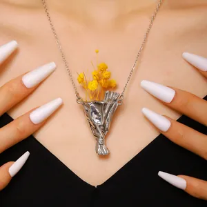 Primo piano della collana con ciondolo a bouquet d'argento e fiori secchi gialli