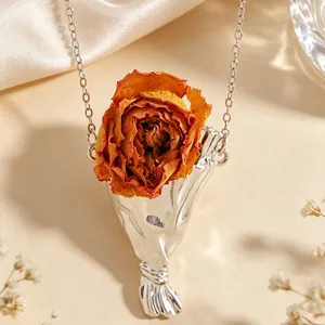 Dettaglio collana bouquet argento con rosa rossa essiccata e finitura testurizzata