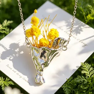 Dettaglio ravvicinato di una collana con ciondolo a bouquet d'argento e fiori secchi