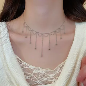 Close-up of elegant silver metal tassel fringe necklace on a female model's neck
