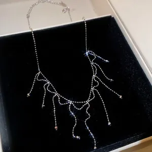 Macro view of metallic tassel necklace with sparkling crystal beads in jewelry box
