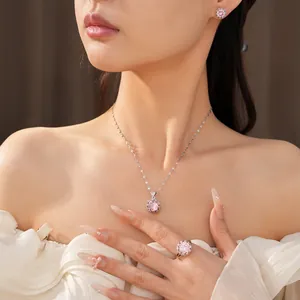 Vue détaillée d'un ensemble élégant collier, boucles d'oreilles et bague en zircon rose.