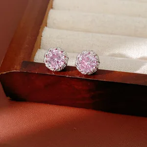 Vue détaillée de boucles d'oreilles rondes en zircon rose sur une monture argentée.