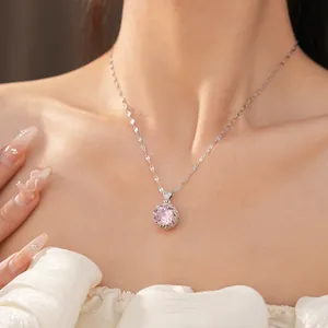Gros plan d'un collier avec pendentif en pierre rose élégante sur le cou d'un modèle